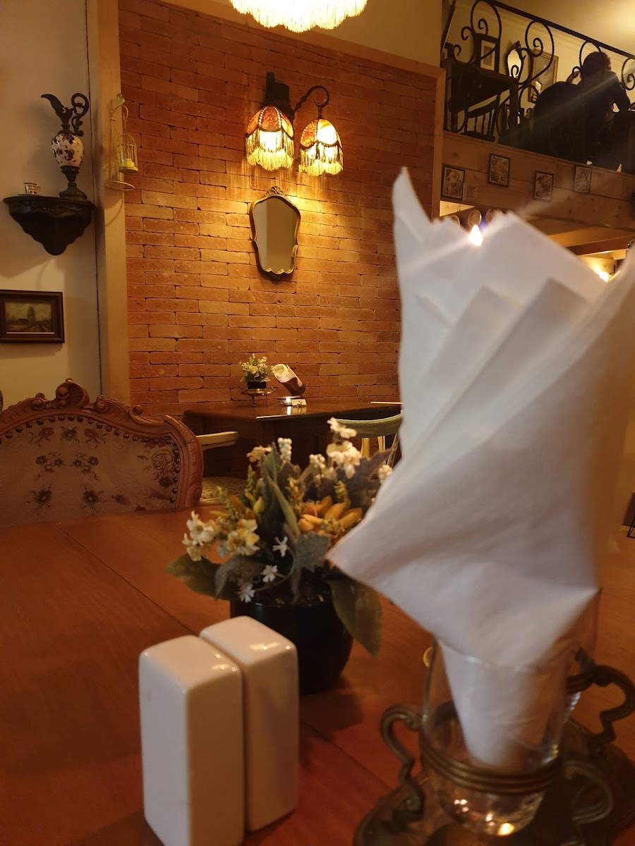 An antique armchair by the brick wall, wine and flowers on the table