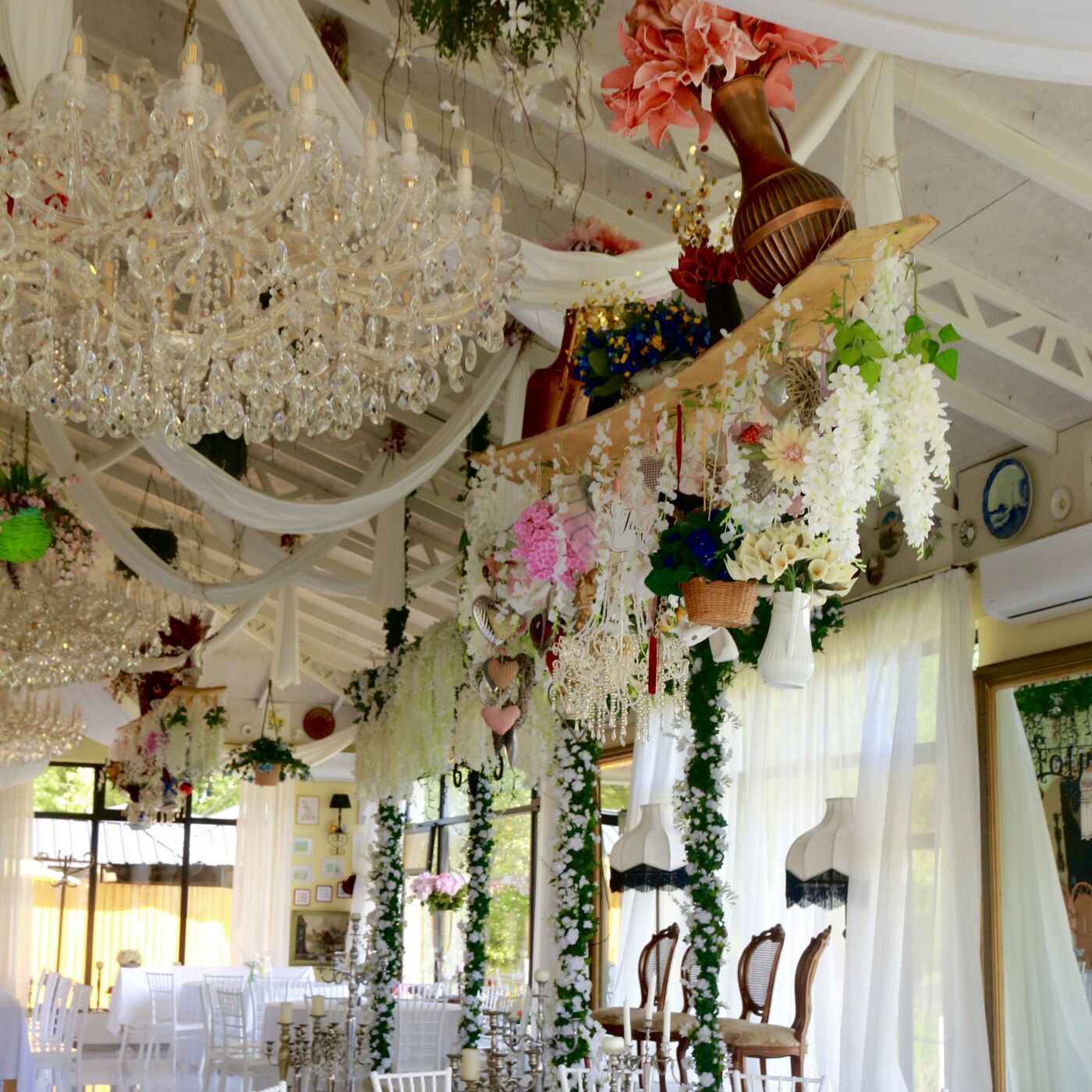 Chandeliers and hanging garlands above the laid tables