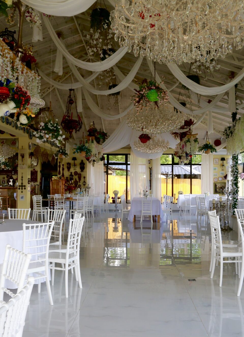 The long hall beneath crystal chandeliers, chairs set either side of the aisle