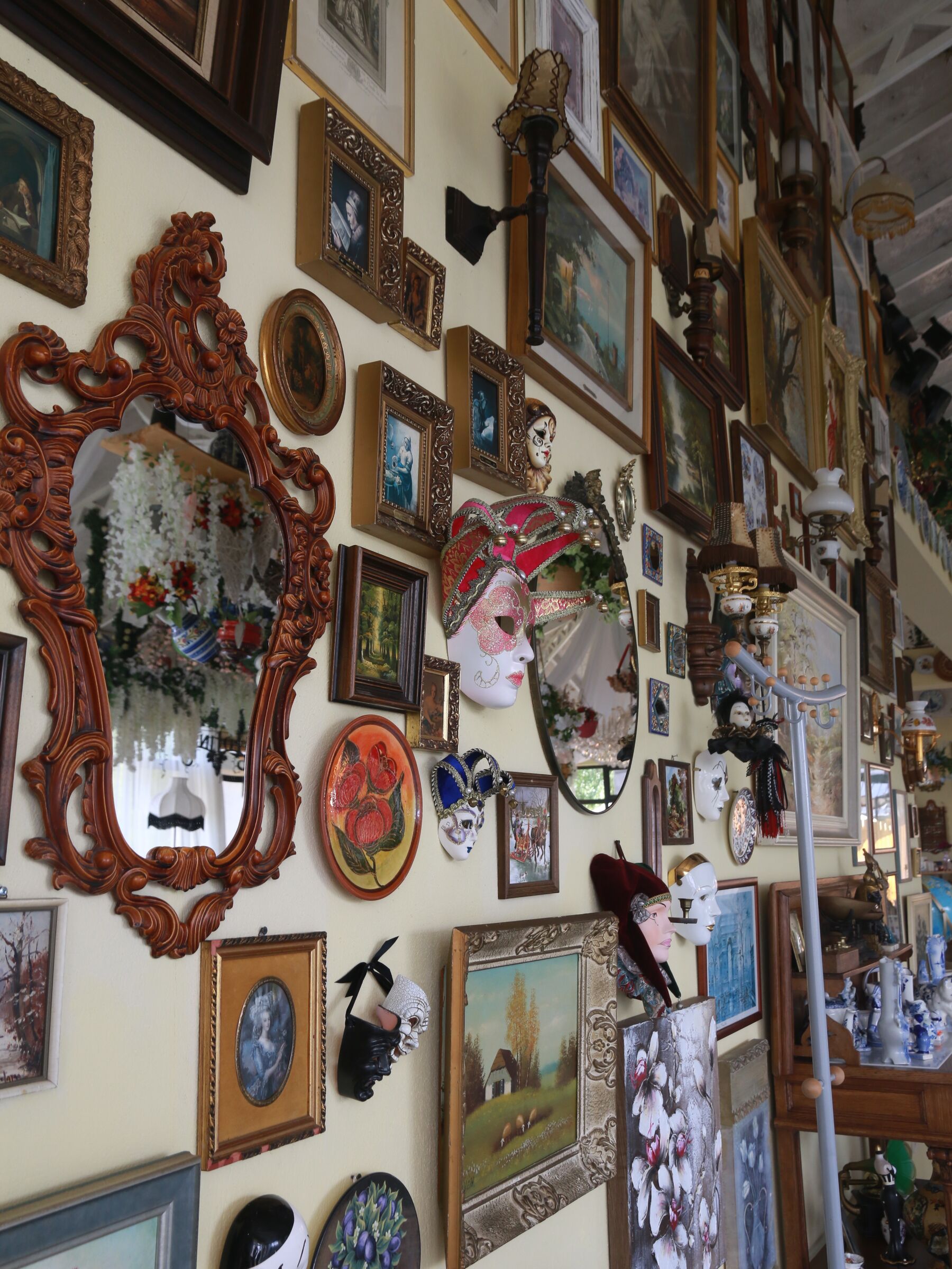 Carnival masks and gilt mirrors crowding the dining-room wall