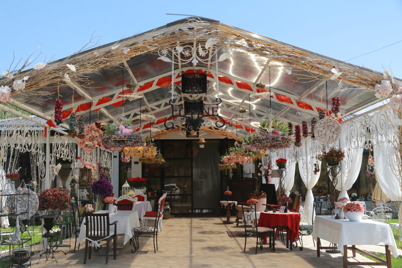 The pavilion under its clear roof, the wrought-iron Fotine sign hanging at its centre